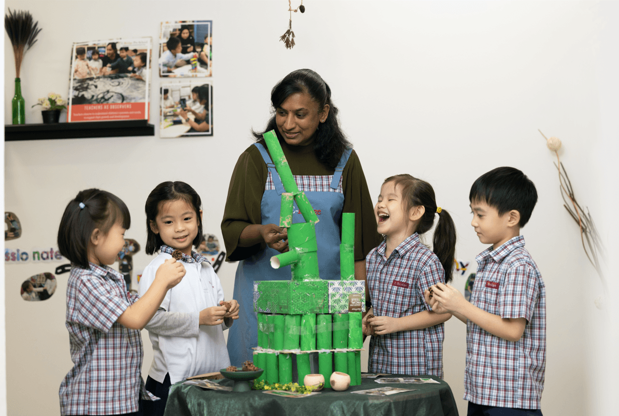teacher guiding students on building a bamboo structure out of toilet paper rolls